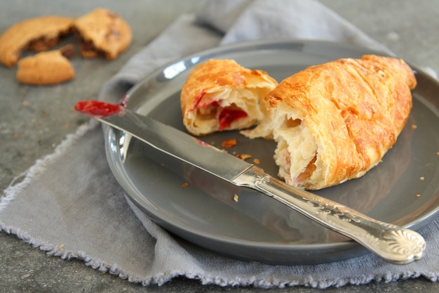 Croissant à la confiture de fraises sur plaque grise