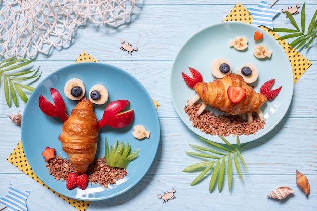Photo croissant de crabe mignon avec des fruits pour le petit déjeuner des enfants
