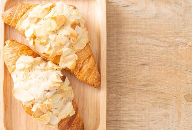 croissant à la crème et aux amandes sur plaque de bois