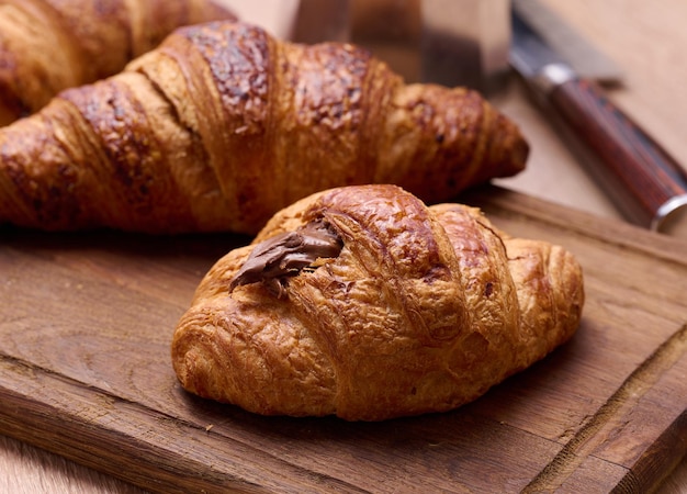 Croissant croustillant cuit au four sur un petit-déjeuner en bois