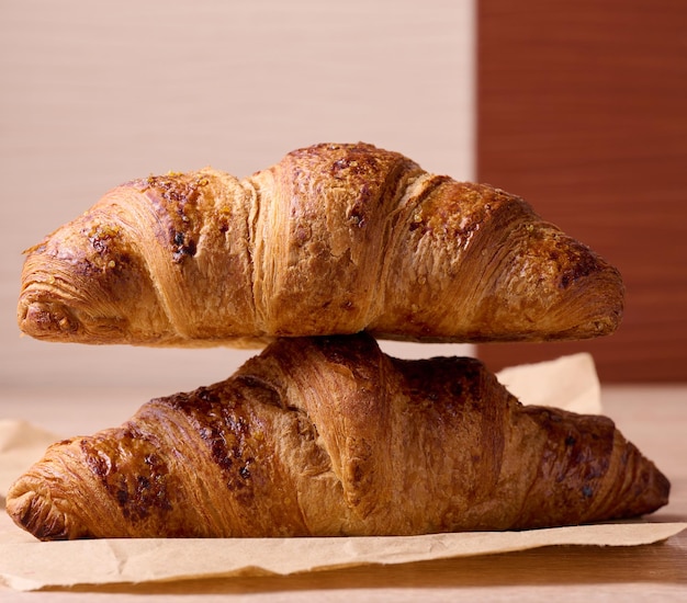 Croissant croustillant cuit au four sur un petit-déjeuner en bois