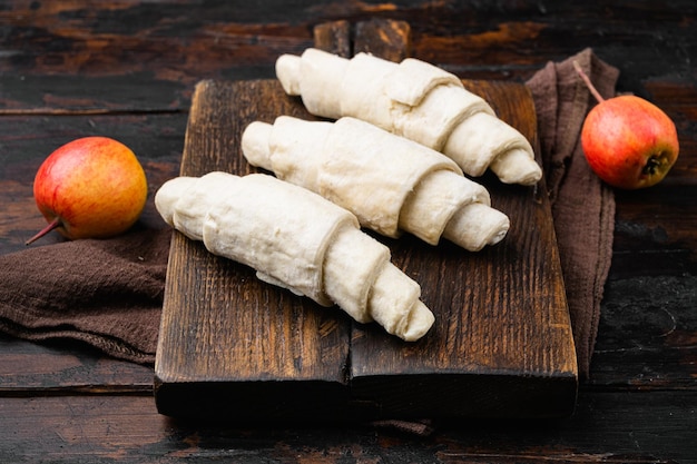 Croissant cru congelé sur le vieux fond de table en bois foncé