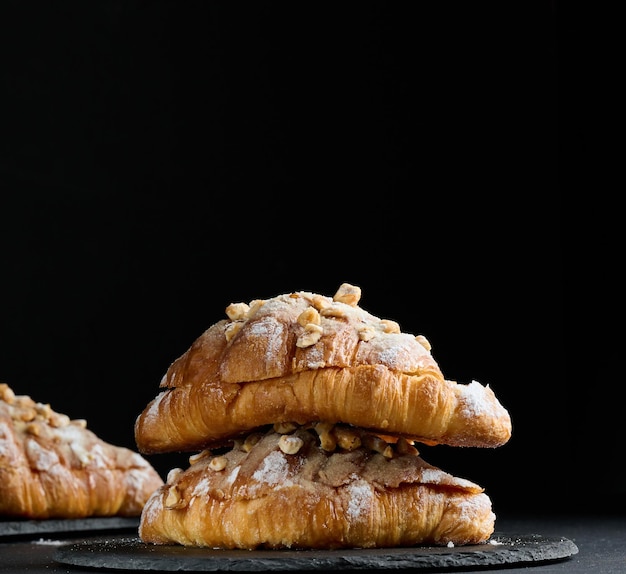 Croissant cuit au four sur une planche et saupoudré de sucre en poudre tableau noir Pâtisseries appétissantes pour le petit déjeunerx9