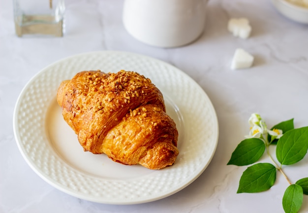 Un croissant et du café sur une surface de marbre