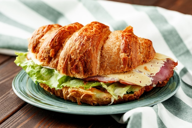 Croissant farci de bacon, fromage et laitue close up