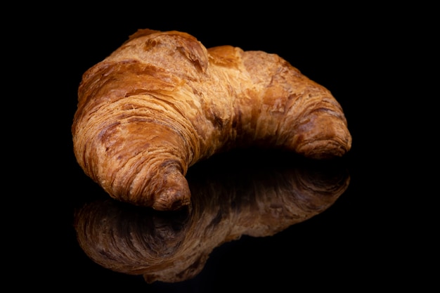 Photo croissant sur fond de studio réfléchissant noir. fond miroir brillant noir isolé pour chaque concept..