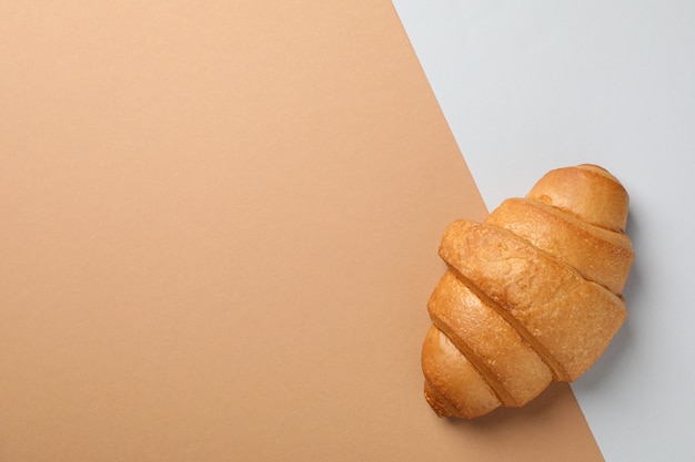 Croissant fraîchement sorti du four sur fond deux tons, vue de dessus