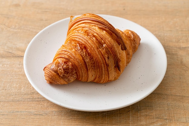 croissant frais sur plaque blanche avec café noir