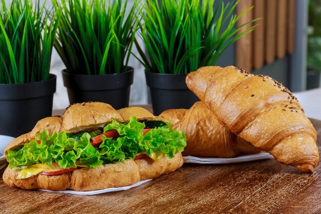 Croissant frais avec salade fraîche et rencontre sur blanc.