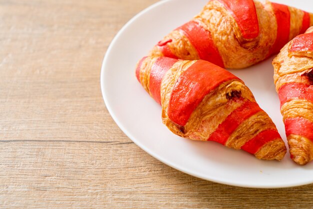 croissant frais avec sauce à la confiture de fraises sur assiette