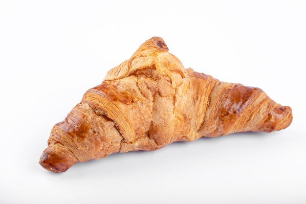 Un croissant frais et savoureux placé sur un fond blanc.