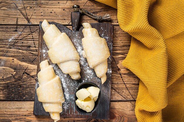 Photo croissant français cru cru sur une planche de bois