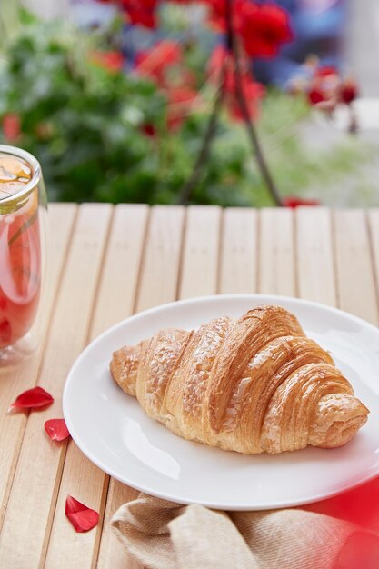 Croissant français esthétique sur l'assiette sur la terrasse du jardin Espace de copie