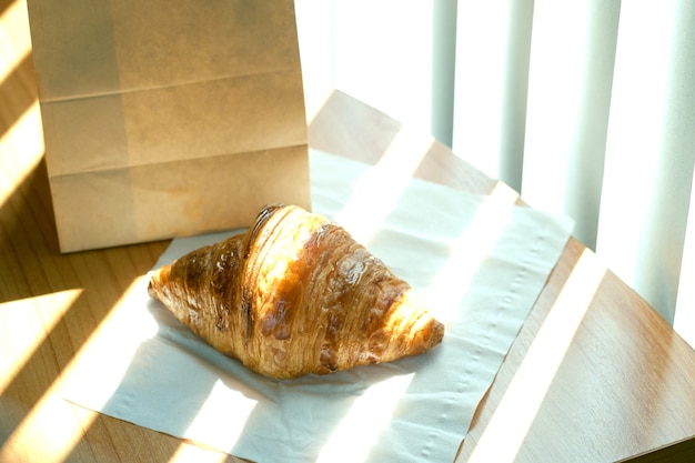 Photo croissant français fait maison sur papier blanc sur la table