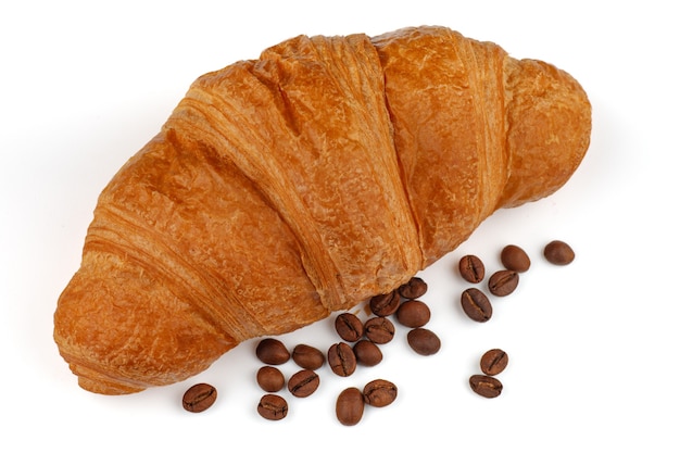 Croissant et grains de café isolés sur blanc