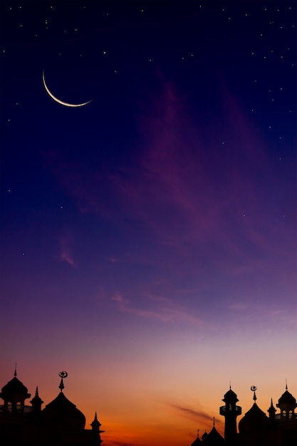 Croissant de lune sur ciel crépusculaire au coucher du soleil avec la lumière du soleil sur les mosquées du dôme