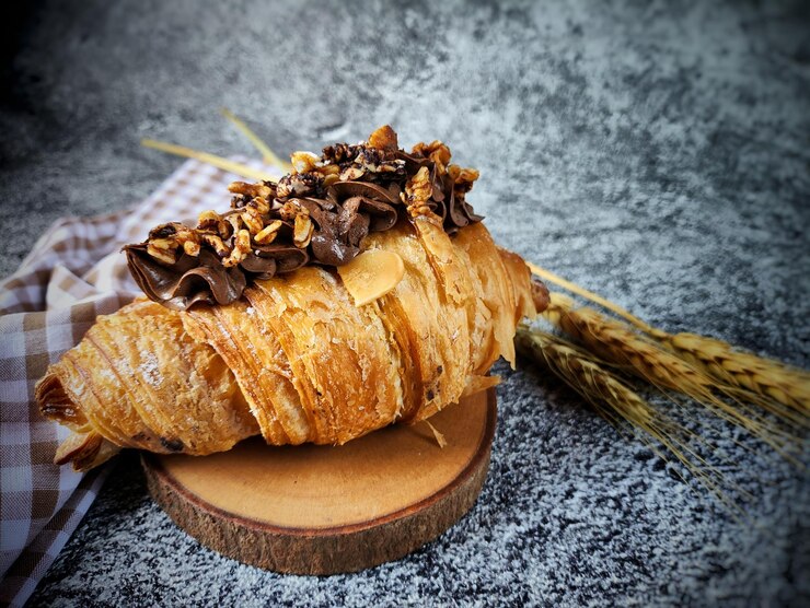 Photo un croissant avec un morceau de chocolat dessus est assis sur une table