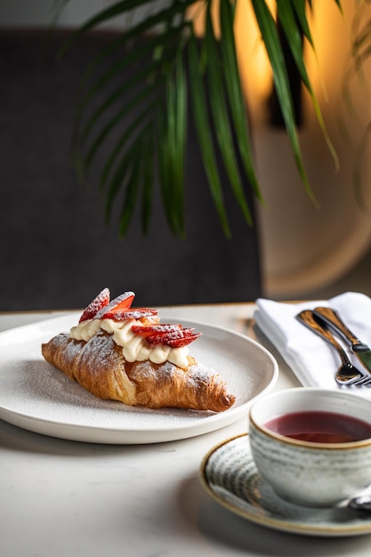 Croissant Pain et thé Croissants sucrés frais avec beurre et petit-déjeuner avec tasse de thé