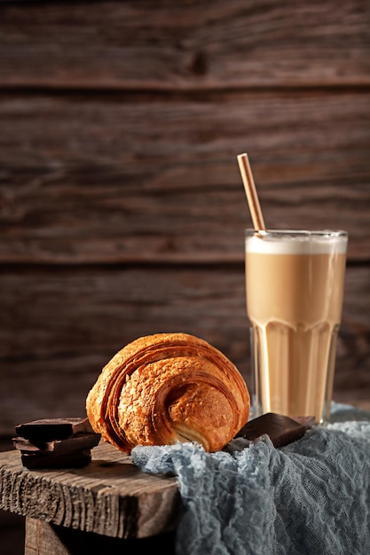 Croissant parfumé fraîchement cuit avec du cacao dans un verre sur un fond en bois