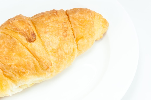 Croissant sur plat blanc sur fond blanc