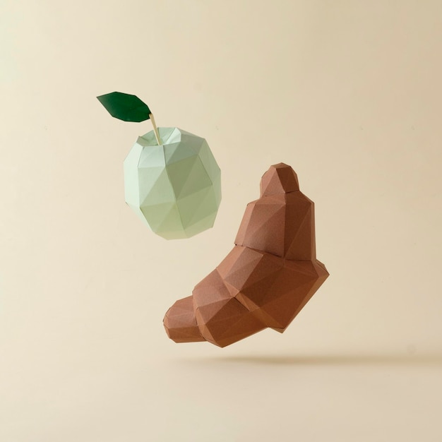 Croissant de polygone 3d au chocolat et lévitation de pomme verte sur fond beige Concept pastel créatif minimal d'aliments et de régimes alimentaires délicieux et sains