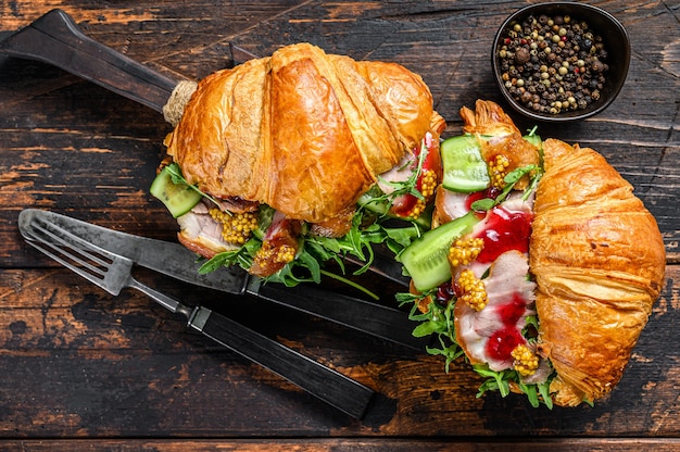 Croissant rempli de jambon et de laitue sur planche à découper en bois