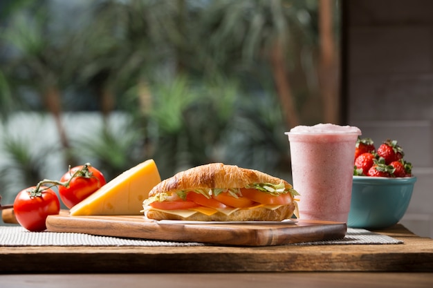 Croissant sandwich avec milkshake aux fraises, fromage et tomate