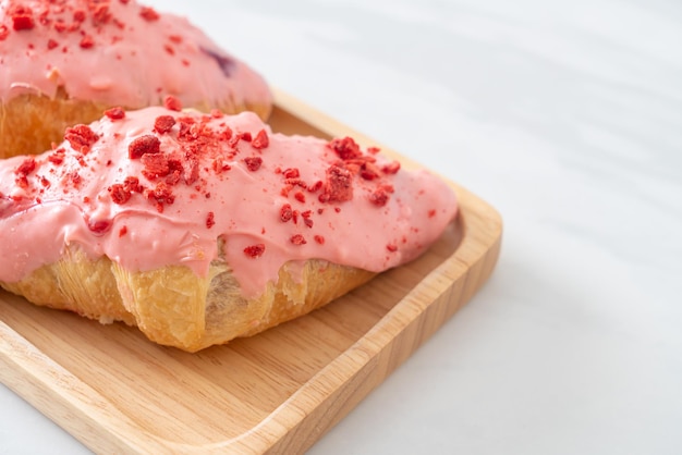 croissant avec sauce chocolat fraise sur plaque de bois