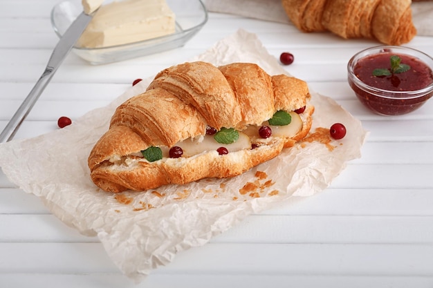 Croissant savoureux avec remplissage sur table en bois