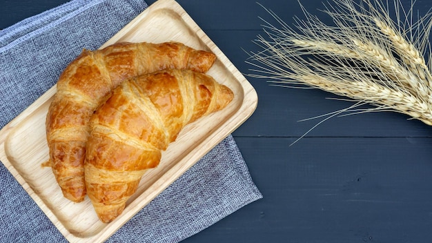 Un croissant sur une table en bois noir.