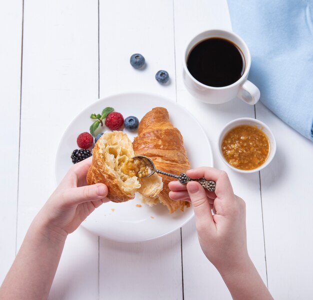 Croissant avec une tasse de café et de baies