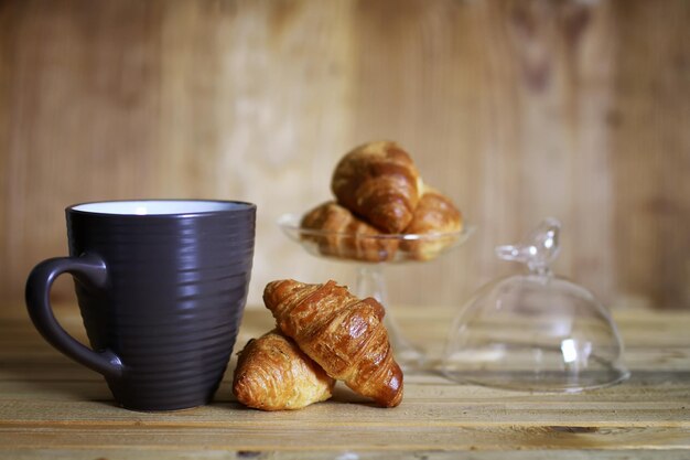 Croissant tasse petit déjeuner fond en bois