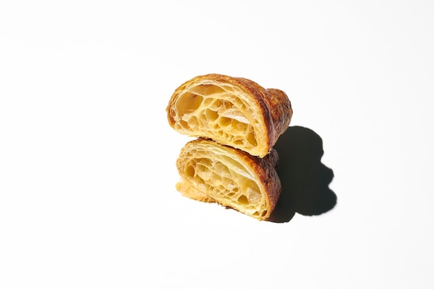 Croissant vide tranché. Demi-croissants avec texture de pâte Lumière dure. fond blanc