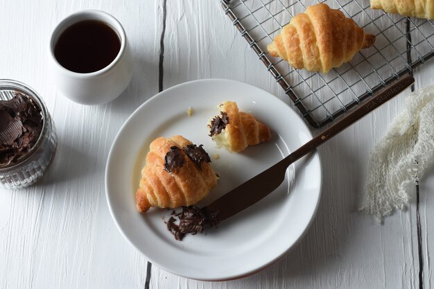 croissantCroissants frais sur un plateau avec un petit pot de confiture pour le petit déjeuner