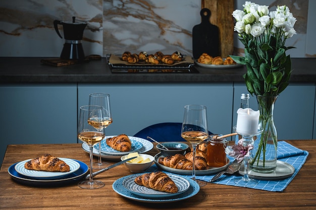 Croissants au beurre et au vin sur une table en bois.