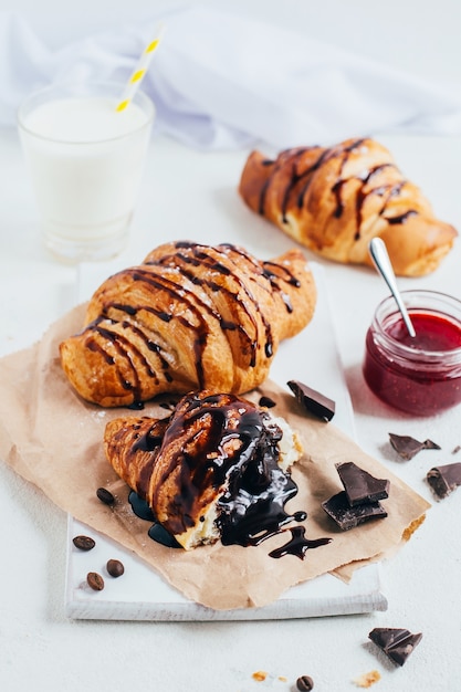 Croissants au chocolat et confiture de fraises sur un gros plan de tableau blanc