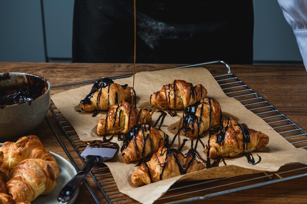 Croissants au chocolat et pépites sur une table en bois.