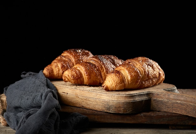 Croissants au four sur planche de cuisine marron