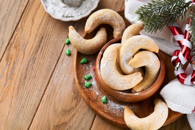Croissants de biscuits de Noël Biscuits de Noël traditionnels faits maison Croissants à la vanille dans une assiette rustique avec des décorations de Noël sur fond rustique en bois ancien Modèle alimentaire Concept de cuisson de vacances