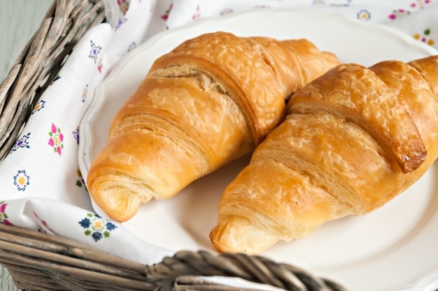 Croissants dans le style romantique dans un panier en osier