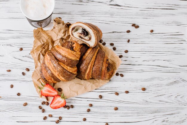 Croissants frais au chocolat et fraises sur le fond en bois