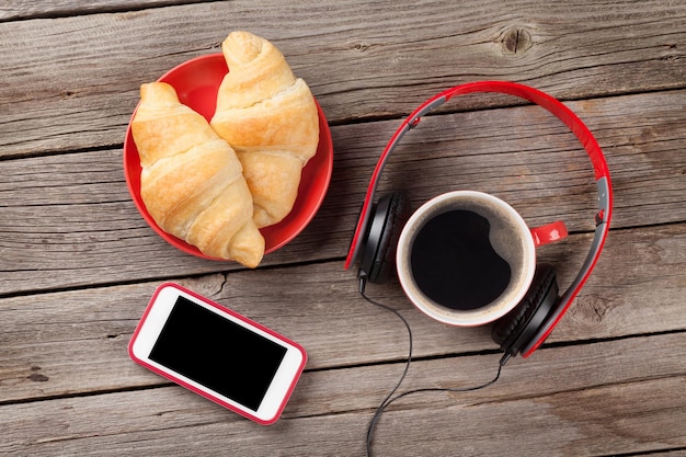 Croissants frais café smartphone et écouteurs