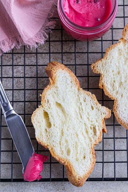 Croissants frais croustillants au miel rose sur grille en métal noir. Vue de dessus.