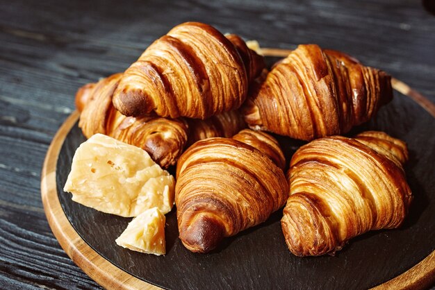 Croissants frais cuits au four. Croissants et petits pains au beurre parfumé chaud sur un support en pierre