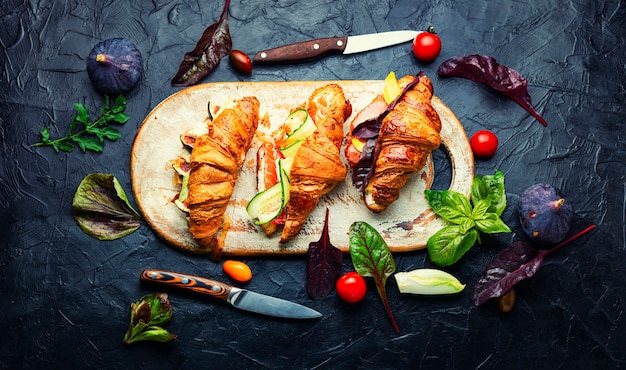 Croissants frais, petit déjeuner sain. Croissants à la truite, bacon de viande, légumes et fruits