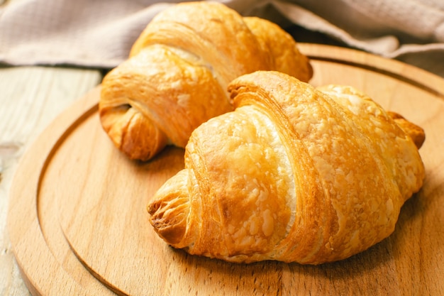 Croissants frais sur une planche à découper en bois