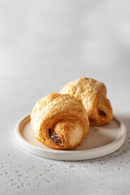 Croissants frais sur une plaque blanche sur fond clair