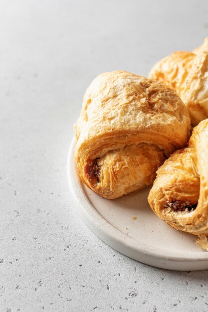 Croissants frais sur une plaque blanche sur fond clair