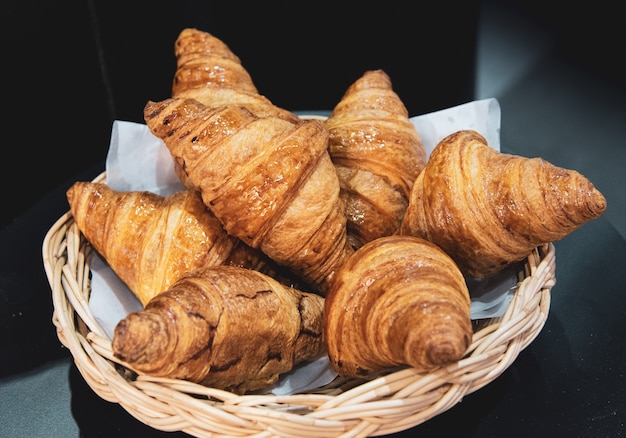 Croissants français sur panier d&#39;osier, fond de boulangerie