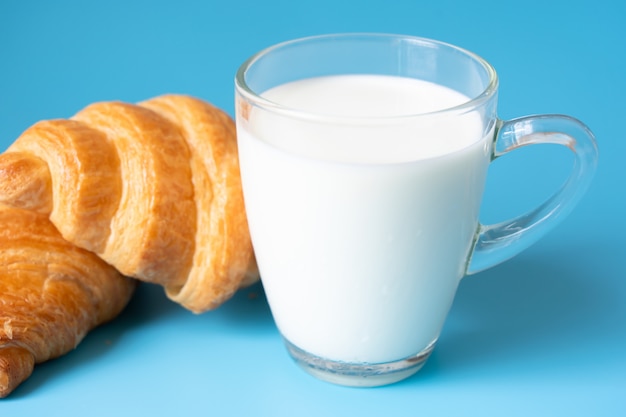 Photo croissants et lait sur fond de couleur.